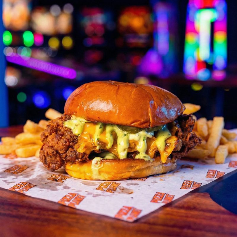 Cluck 'N Run - buttermilk-fried chicken loaded with melted cheese sauce and herb mayo on a brioche bun, with fries.