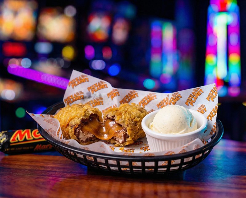 Behind Mars Bars - deep-fried Mars bar in a Pizza By The Planet basket, oozing gooey caramel and chocolate, served with vanilla ice cream.