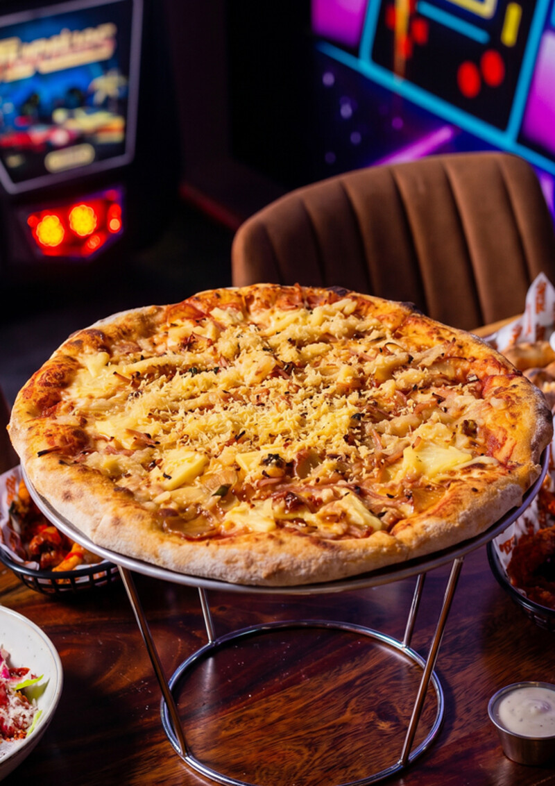 Pineapple Express pizza - May/June special. Pineapple-glazed shredded ham, candied spiced pineapple, dehydrated pineapple parmesan grated over a mozzarella base.
