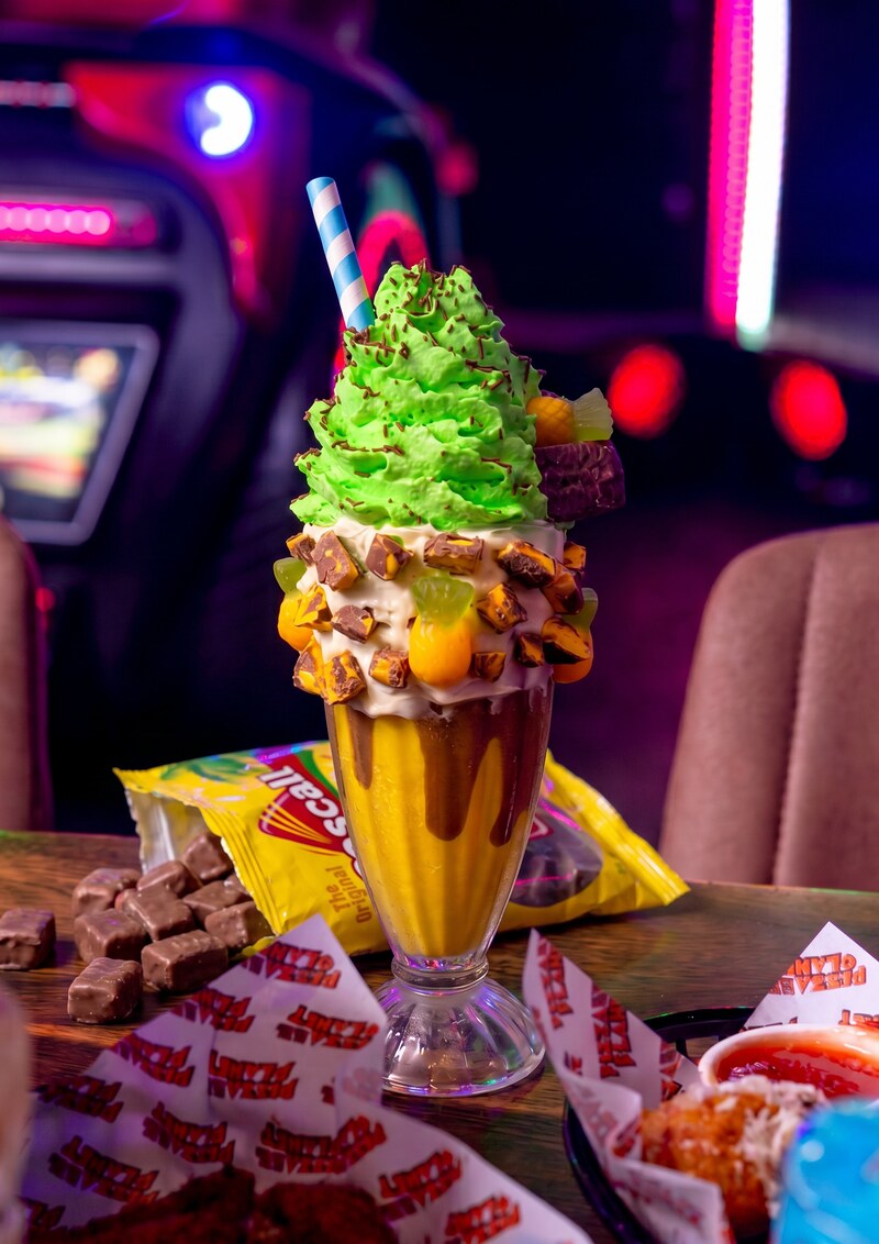 Pineapple Lomps shake - May/June special. Pineapple-choc shake topped with green pineapple cream, choc sprinkles, pineapple gummies and a Pineapple Lump candy.